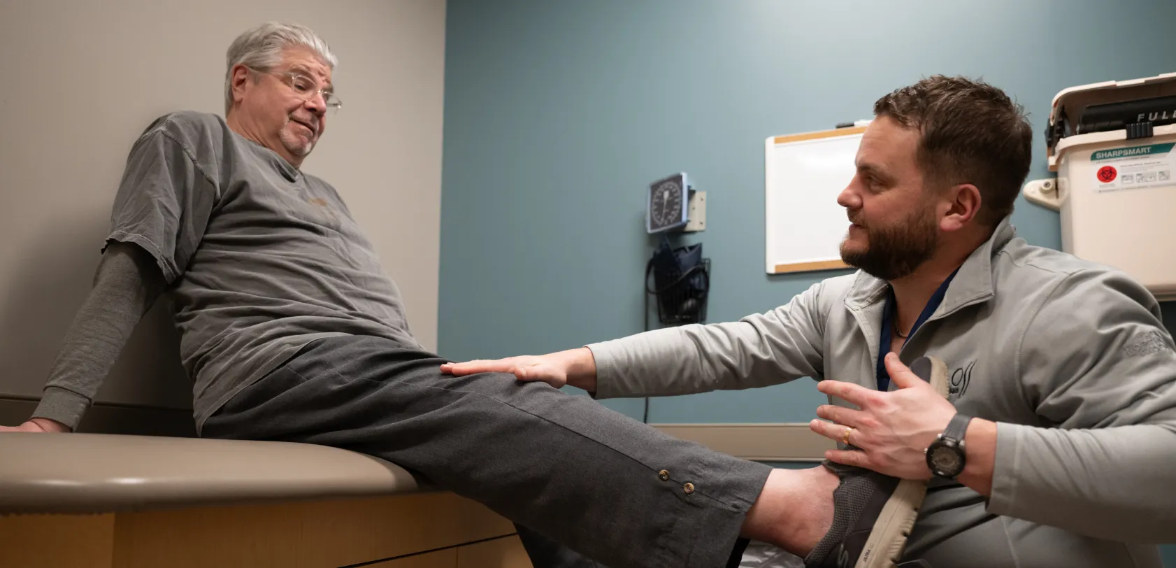 OSS orthopaedic clinician examining an older patient’s knee