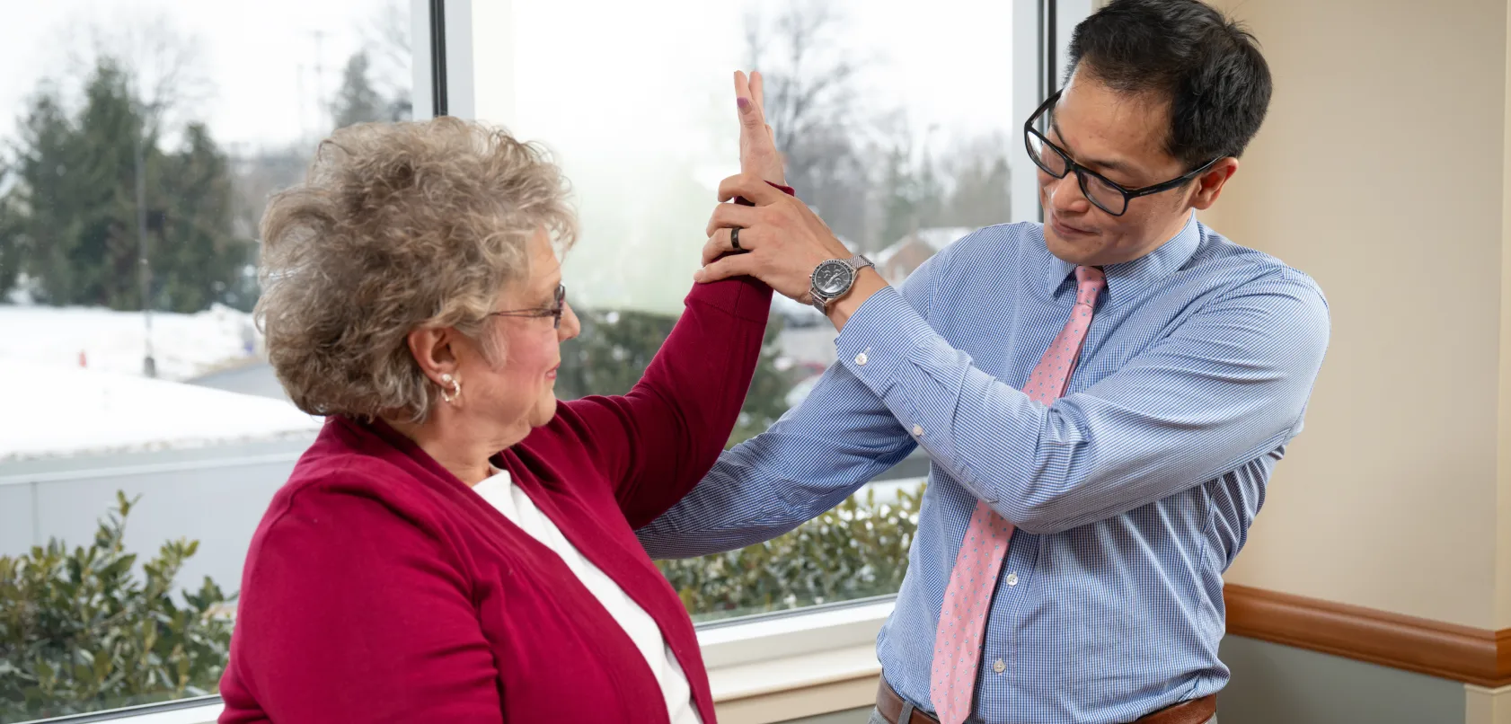 OSS orthopaedic physician evaluating an older patient’s shoulder mobility