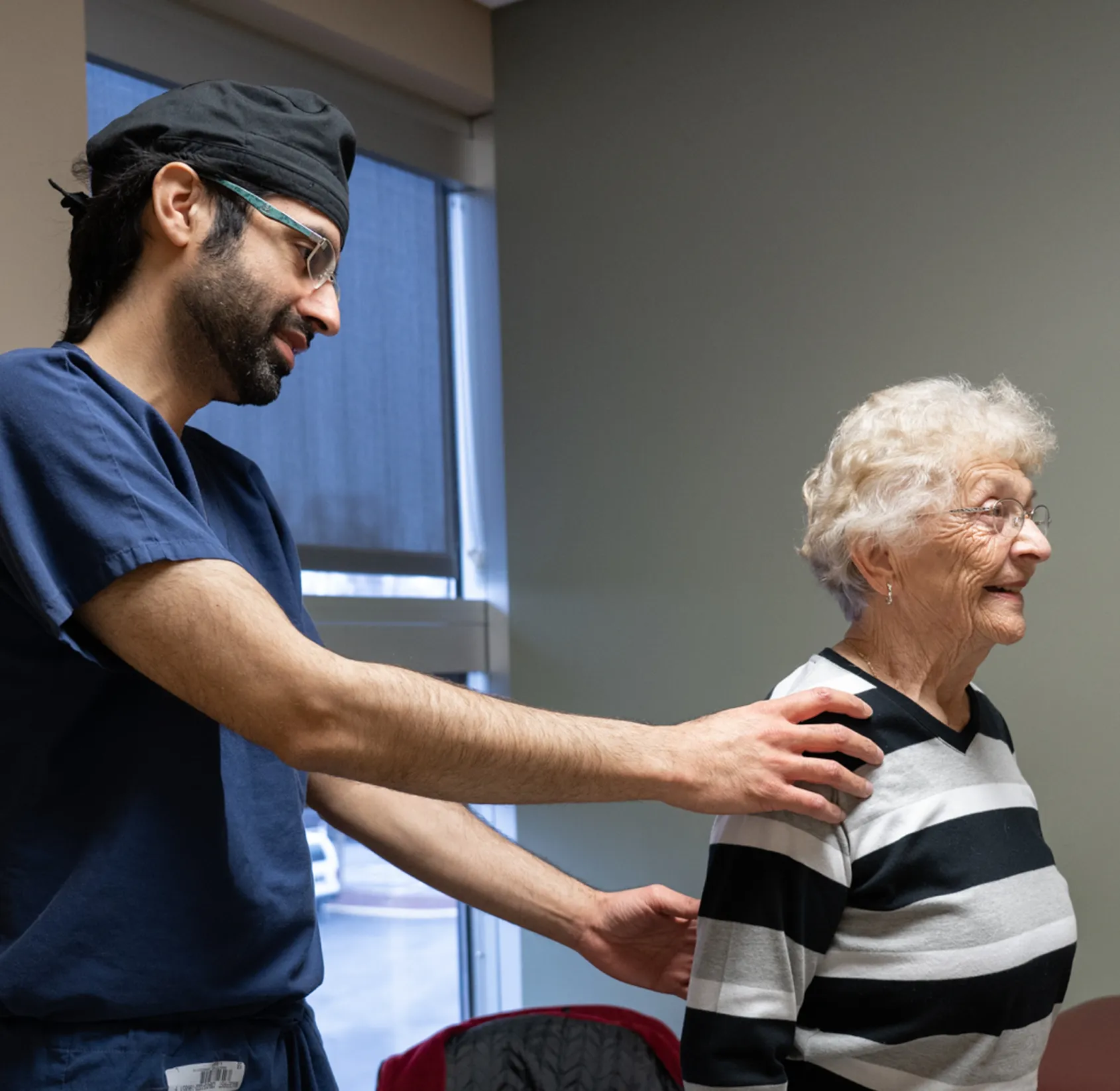 OSS Health specialist examining an older patient’s shoulder and upper back