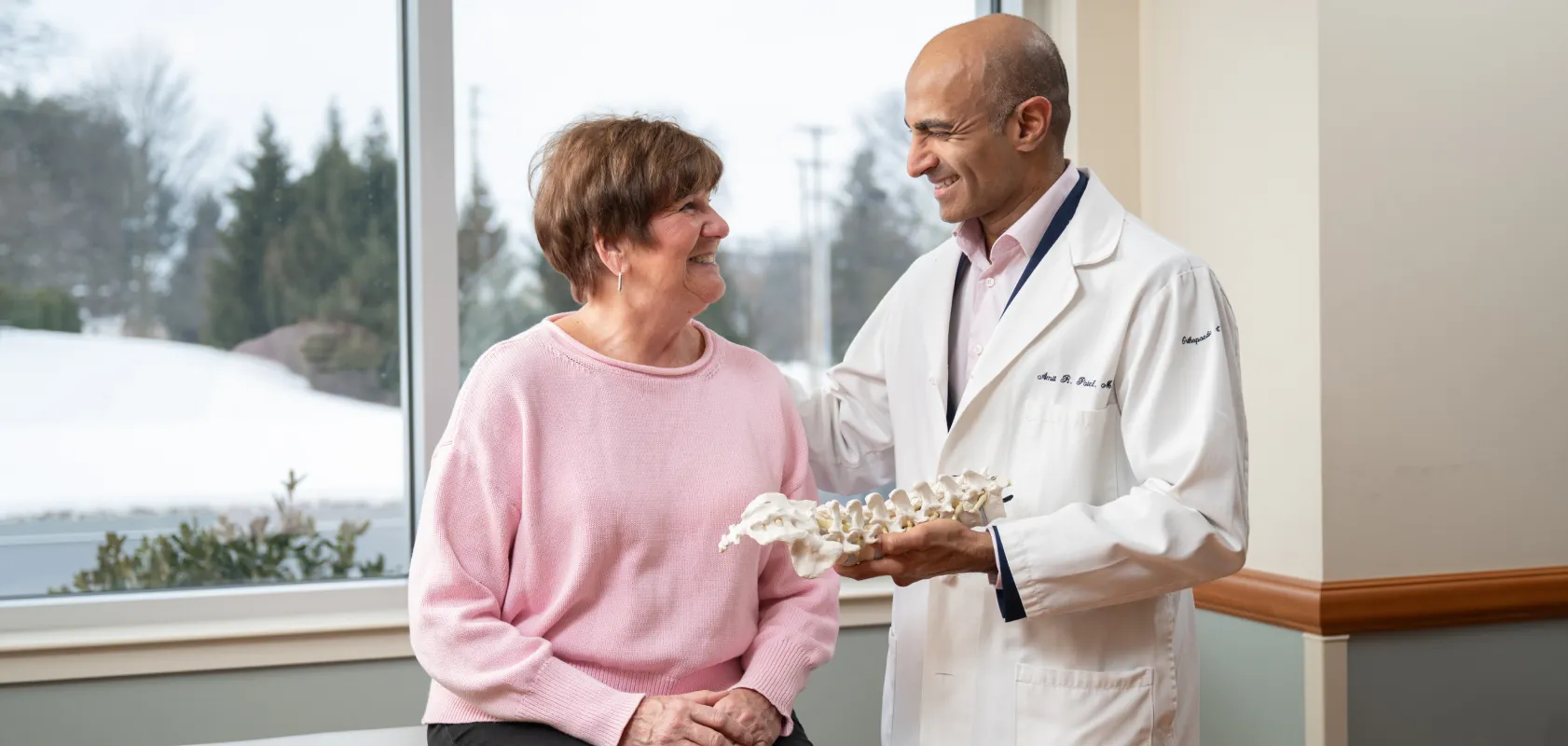 OSS Health spine specialist discussing a spinal model with a patient