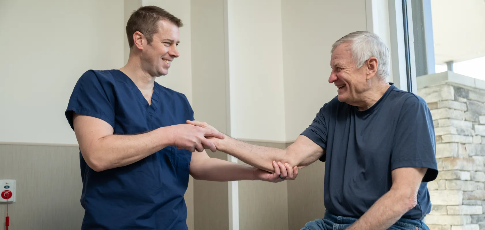 OSS orthopaedic clinician examining an older patient’s wrist and forearm